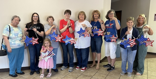 group of ladies holding patriotic doorhangers