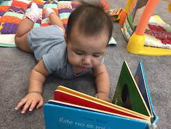 infant looking at book