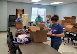 volunteers sorting and packing donations