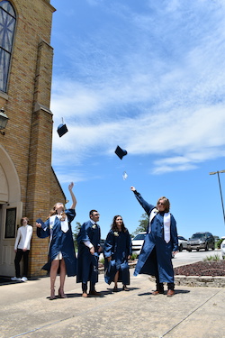 graduating students throwing caps