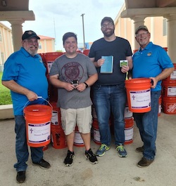 volunteers with gift cards and flood recovery buckets