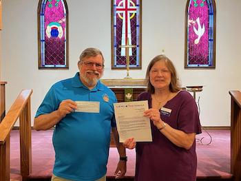 Mission grant check presentation between 2 people