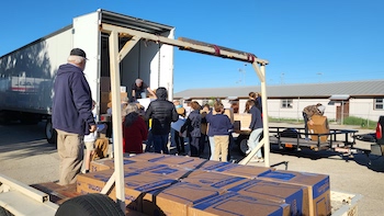 people loading boxes on semi-truck